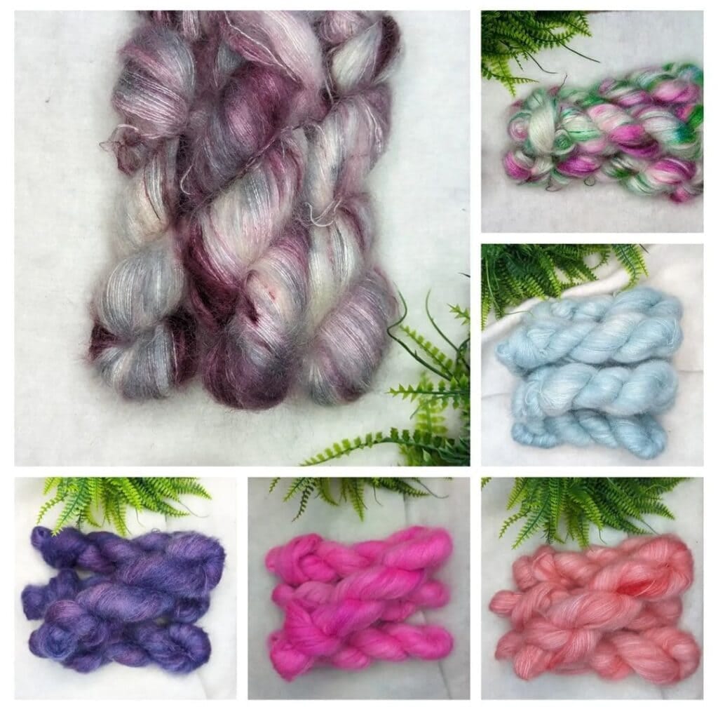A collage of yarn bundles on a light surface next to green ferns. The top left bundle is a mix of purple, grey, and white. The other four bundles from the Dye Studio are in shades of blue, purple, pink, and coral. Another mix of green and pink yarn by Yarn Divas is on the top right corner.