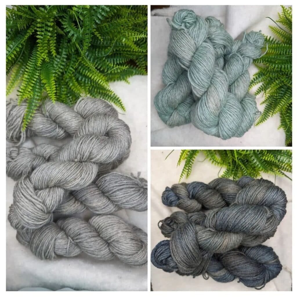 A collage of three yarn sets from Dye Studio in different shades of gray and blue. The top right set is a light bluish-gray, the bottom left set is a neutral gray, and the bottom right set is a darker gray-blue. Fern leaves frame these Diva-worthy yarns on a white surface.